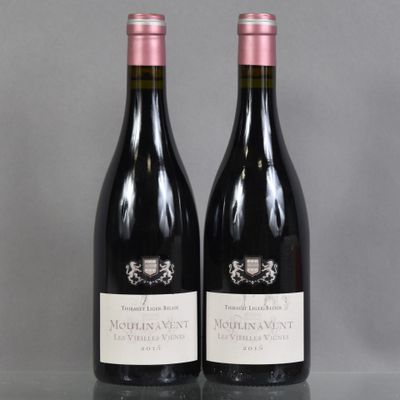 two bottles of wine sitting on top of a table next to each other
