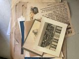 a pile of old papers on the floor next to a chair