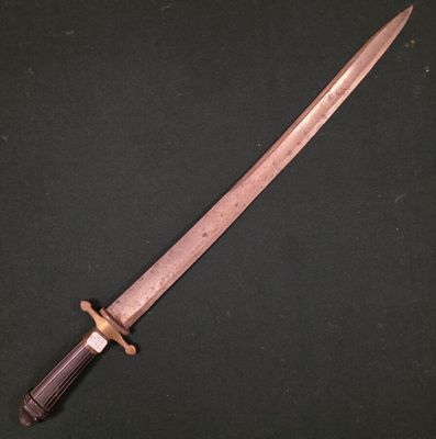 un couteau avec un manche en bois posé sur une surface noire