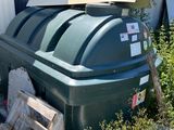a large green trash can next to a pile of wood
