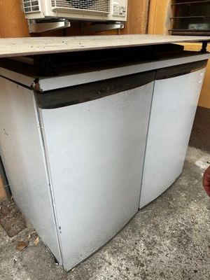 un petit réfrigérateur blanc posé dans un coin d'une pièce