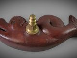 an image of a wooden fish with a brass plate on it