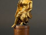 two statues of a man and a woman sitting on a pedestal