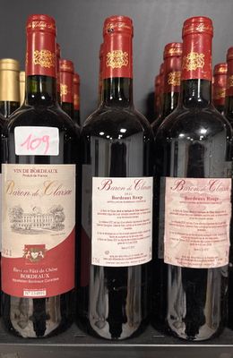 bottles of red wine are lined up on a shelf in a store