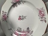 a white plate with a pink rose design on it