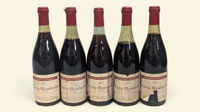 quatre bouteilles de vin sont alignées sur une surface blanche