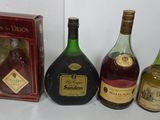 three bottles of liquor are sitting next to a box of wine