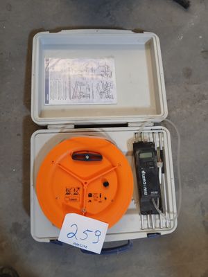 une boîte contenant une télécommande et d'autres objets, posée par terre