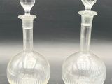 pair of clear glass decanters on a black surface