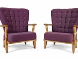 pair of purple upholstered chairs with wooden legs and arms