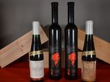 three bottles of wine sitting next to a wooden box on a table