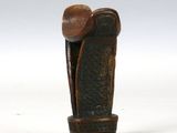une vieille sculpture en bois représentant un homme coiffé d'un chapeau