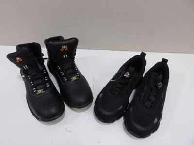 trois paires de bottes de travail noires sont alignées sur une table