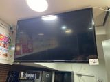 a large flat screen tv mounted on the wall in a kitchen