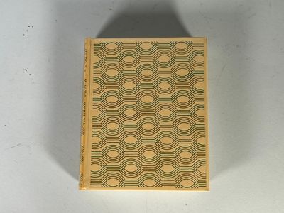 un vieux livre posé sur une table blanche à côté d'un mur blanc