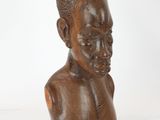 une image représentant une sculpture en bois représentant une tête d'homme sur fond blanc