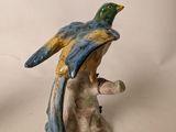 a figurine of a bird perched on a tree branch