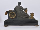 a statue of a woman sitting on a table with a clock