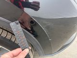 a person holding a piece of paper near a car door