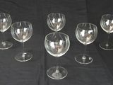 Plusieurs verres à vin vides sont alignés sur une table noire