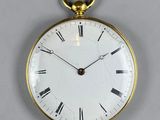 a gold pocket watch with roman numerals on the face