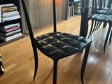 a black chair in the middle of a wooden floor
