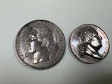two silver coins with a portrait of a man and a woman on them