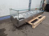 a glass display case with three pans of food on it