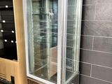 a glass display case in the corner of a room