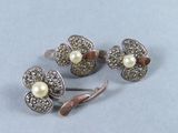 trois bijoux en argent et en perles posés sur un fond bleu