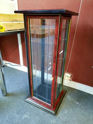 a glass display case with a clock inside of it