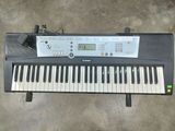 an electronic keyboard sitting on top of a floor next to a wall