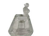 a clear glass perfume bottle with a bird on top of it