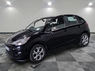 la petite voiture noire est garée dans le garage sur un sol en damier