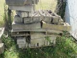 a pile of bricks sitting in the grass next to a fence