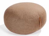 a close up of a round ottoman sitting on a white surface