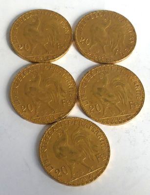 six gold coins are arranged on a white surface