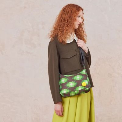 the woman is wearing a green dress and a green purse