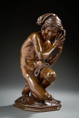 une statue en bronze représentant un homme à genoux, les mains sur le visage