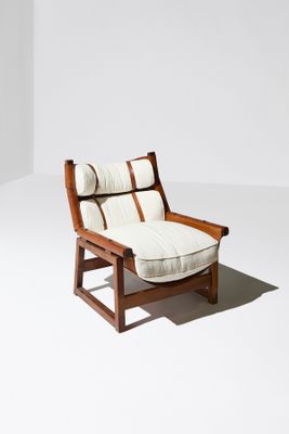 une image représentant une chaise avec un coussin posé dessus, dans une pièce blanche