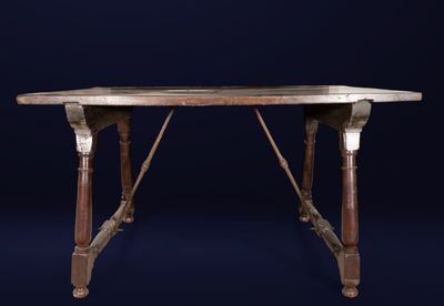 an old wooden table with a marble top on a dark blue background