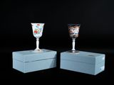 deux verres à vin posés sur une boîte bleue
