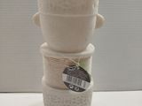 a stack of three ceramic pots with a tag on them