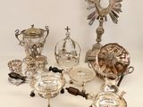 several silver and glass items are arranged on a white surface