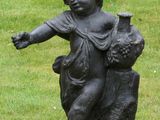 a statue of a boy with a bird on a stump