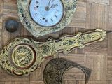 une horloge posée par terre à côté d'autres objets