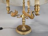 a gold candelier that has a bird on it