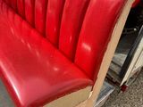 a red bench that is sitting in the back of a truck
