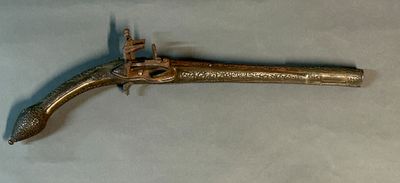 an old brass pistol with a wooden handle on a white surface