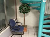 une chaise bleue placée devant un escalier en colimaçon bleu